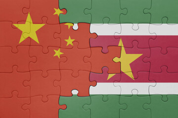 puzzle with the colourful national flag of suriname and flag of china .