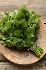 Bunch of fresh coriander on wooden table, top view