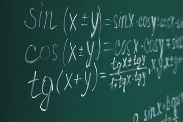 Many different math formulas written on chalkboard