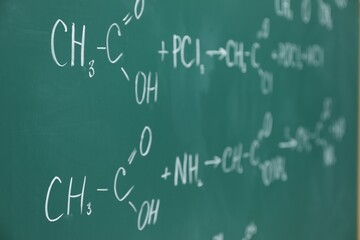 Chemical formulas written with chalk on green board