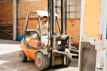 Man Operating Forklift at Industrial Warehouse During Sunny Afternoon