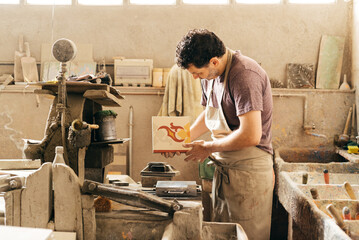 Skilled Worker Creating Decorative Cement Tiles in a Factory During the Day