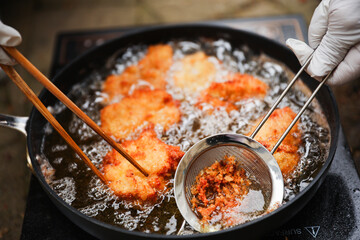 golden, crispy fried chicken pieces in bubbling oil, symbolizing indulgence and temptation