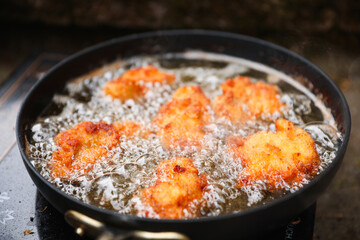 golden, crispy fried chicken pieces in bubbling oil, symbolizing indulgence and temptation