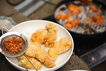 golden, crispy fried chicken pieces in bubbling oil, symbolizing indulgence and temptation