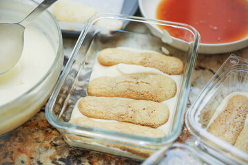 hands delicately layering ingredients to create a luscious tiramisu, showcasing the artistry of homemade desserts