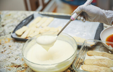 hands delicately layering ingredients to create a luscious tiramisu, showcasing the artistry of homemade desserts