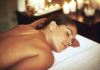 Relaxing, woman and zen in salon for treatment, massage and wellness with cosmetics. Candles,...