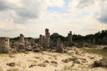 A group of stone pillars rising from a desert-like landscape at the Pobiti Kamani stone forest near...