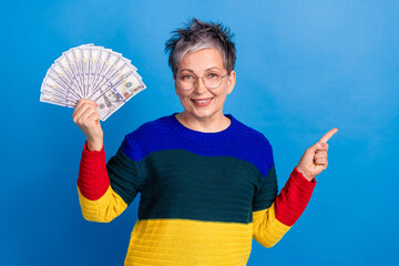 Photo of lovely rich senior woman wear stylish clothes hold banknotes empty space isolated on blue...