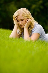 Fototapeta premium Young Girl Laying On Grass