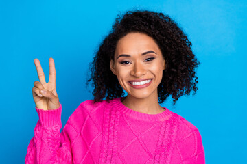 Photo of nice young girl show v-sign wear pink sweater isolated on blue color background