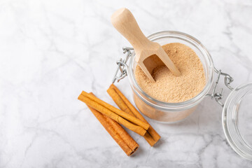 Cinnamon sugar on a texture background. Homemade cinnamon sugar in a bowl on background. Brown sugar. Spice mixture for drinks and baking. Place for text. Copy space.