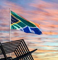 The South African flag against a sunset or sunrise background.