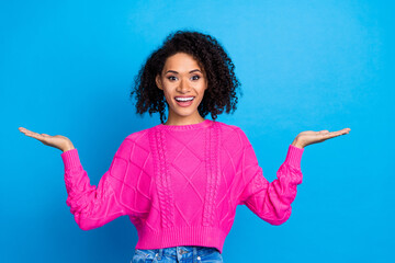Photo of nice young girl arms hold empty space wear pink sweater isolated on blue color background