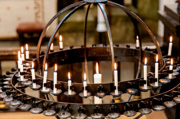 Lit candles in a candelabra in a church. Concept of spirituality and faith. 