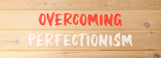 Overcoming perfectionism symbol. Concept words Overcoming perfectionism on beautiful wooden wall....