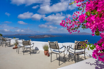 Romantic couple outdoor white marble tables chairs on terrace with flowers overlooking sea, Oia...