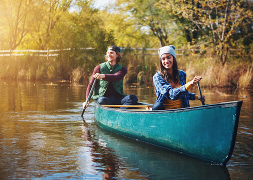 Lake, canoe and couple with nature, vacation and happiness with love, romance and bonding together. Water, river or man with woman, environment or holiday with weekend break, relationship or activity