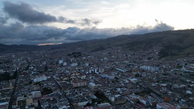 Toma a&eacute;rea de un paisaje urbano en c&aacute;mara r&aacute;pida del atardecer de un municipio con nubes pasando sobre el cielo