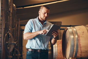 Employee, man and browsing tablet in brewery as manager with research on product, process or...