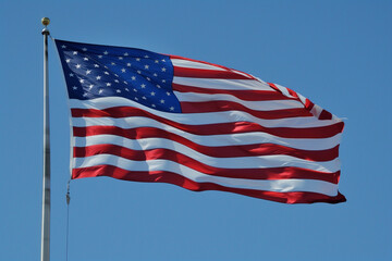Obraz premium **: The American flag flutters against a clear sky, its stars and stripes now shimmering in metallic silver. The abstract lines intersect, representing unity and progress. A digital representation of 
