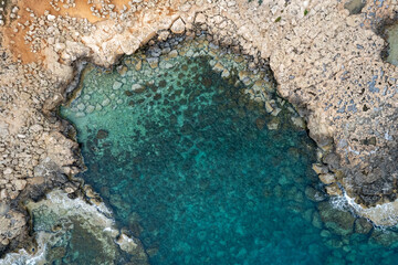 Drone aerial of rocky sea coastline transparent turquoise water. Seascape top view.