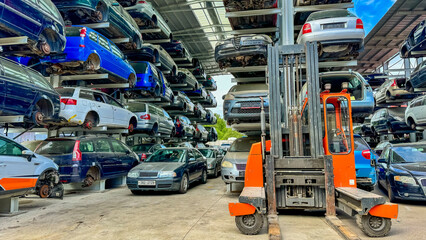 Fototapeta premium Wrecked cars are arranged at the junkyard for eco-liquidation.