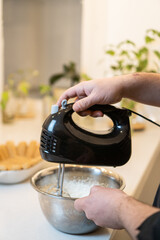 whipping cream with black electric mixer