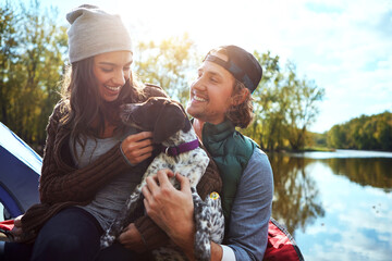 Adventure, couple and dog with love of camping in nature forest, sunshine and bond, smile and...