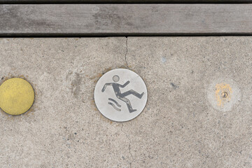 metal logo on the ground (warning slippery)