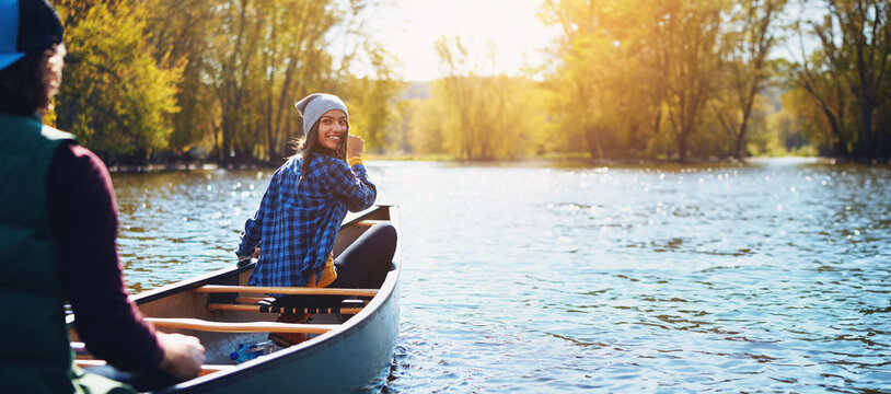Couple, canoe and lake for nature holiday exploring or rowing outdoor, environment or journey. Man, woman and happy or travel weekend or river morning at vacation resort in Colorado, calm or forest