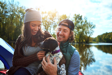 Couple, dog and adventure with love of camping in nature forest, sunshine and bond, smile and...