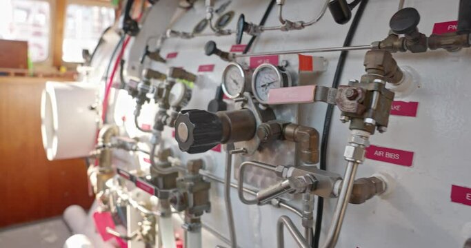 Side view of hyperbaric chamber with valves and pipes