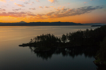 Fototapeta premium Abner Point on Lummi Island with Mt. Baker in the background. Seen from the Aiston Preserve with Smugglers Cove in the foreground and Bellingham Bay and the city of Bellingham in the distance.