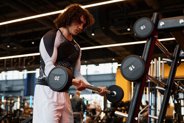 Side view portrait of muscular man lifting heavy barbell during strength training in gym copy space