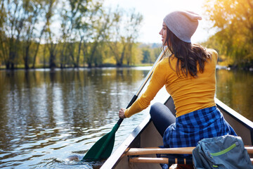 Woman, back and canoeing for water sport in nature, wellness hobby and single blade paddle for...