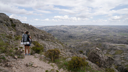 Outdoor activities. View of a woman hiking along a foot trail high in the rocky mountains.