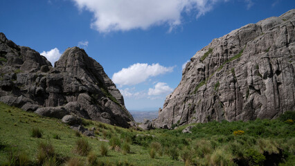 Panorama view of the v shaped valley high in The Giants rock massif. View of the rocky mountains and green field in a sunny summer day