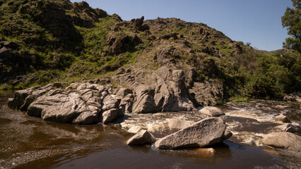 View of river Yuspe flowing across the rocky hills in the rock massif Los Gigantes in Cordoba, Argentina.