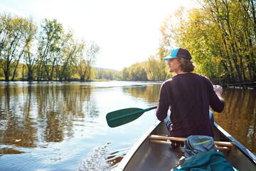 Man, canoeing and lake rowing in nature for morning adventure or exercise, exploring or island....