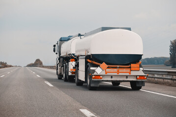 Petrol truck on highway hauling fossil oil refinery products. Fuel delivery transportation....