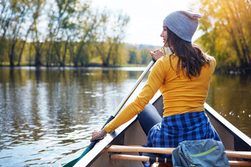 Woman, back and canoeing in forest on water, wellness hobby and backpack for supplies with paddle...