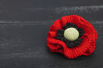 Memory Day concept. Handmade crochet poppy flower. Traditional symbol, flat lay