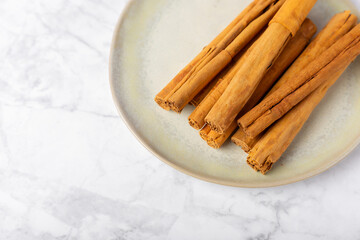 Ceylon cinnamon.Cinnamon sticks on a textured wooden background. Cinnamon roll and powder. Spicy spice for baking, desserts and drinks. Fragrant ground cinnamon. Close-up. Place for text. copy space