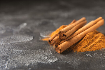 Ceylon cinnamon.Cinnamon sticks on a textured wooden background. Cinnamon roll and powder. Spicy...