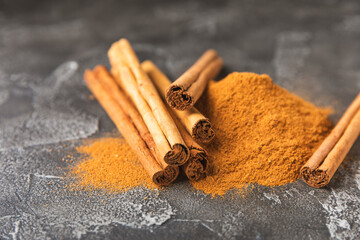 Ceylon cinnamon.Cinnamon sticks on a textured wooden background. Cinnamon roll and powder. Spicy spice for baking, desserts and drinks. Fragrant ground cinnamon. Close-up. Place for text. copy space