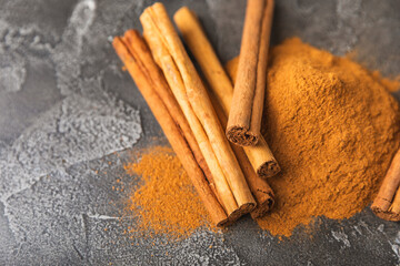 Ceylon cinnamon.Cinnamon sticks on a textured wooden background. Cinnamon roll and powder. Spicy...