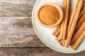 Ceylon cinnamon.Cinnamon sticks on a textured wooden background. Cinnamon roll and powder. Spicy spice for baking, desserts and drinks. Fragrant ground cinnamon. Close-up. Place for text. copy space
