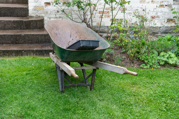 whispering secrets in a garden's embrace, where the wheelbarrow rests on lush green grass